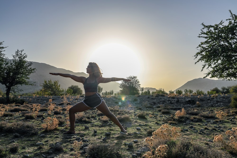 woman in black bikini standing on rocky shore during daytime