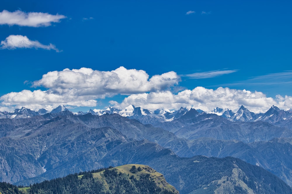 green and white mountains under blue sky and white clouds during daytime