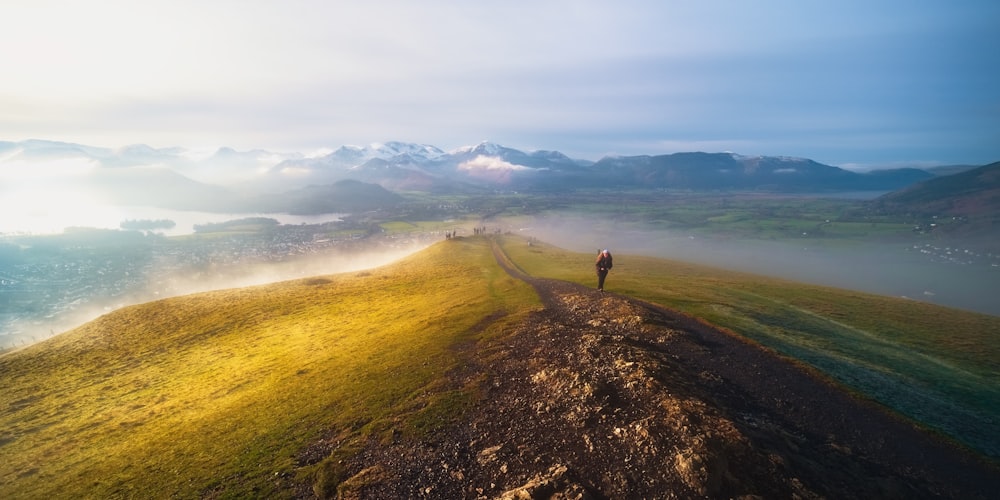 person walking on brown field during daytime