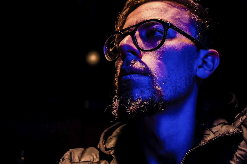 man in black framed eyeglasses and black jacket