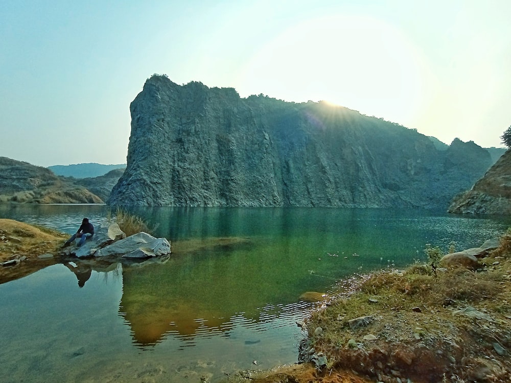 body of water near mountain during daytime