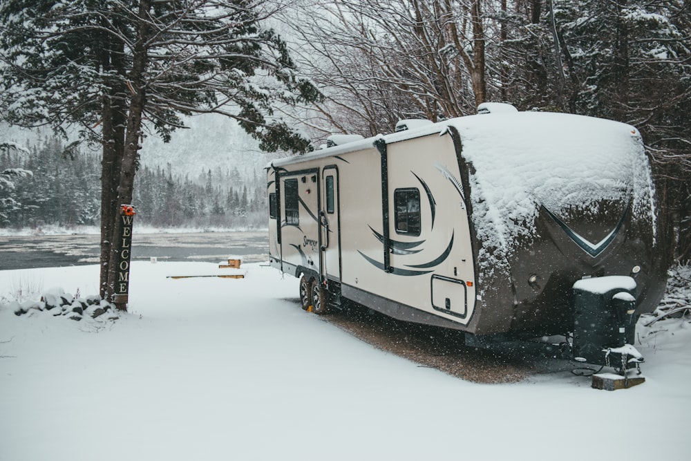 white and brown camper trailer on snow covered ground