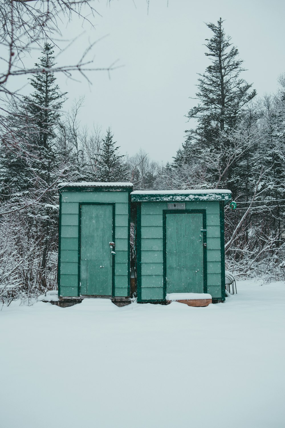 green wooden house covered with snow during daytime