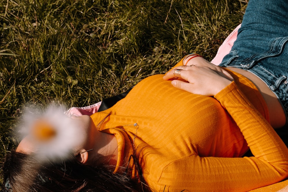 woman in orange dress lying on green grass