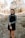 woman in gray long sleeve shirt and black skirt standing on brown dried leaves during daytime