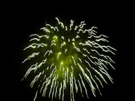 Close-up of eco-friendly Ayyan green crackers emitting soft green sparks with minimal smoke.