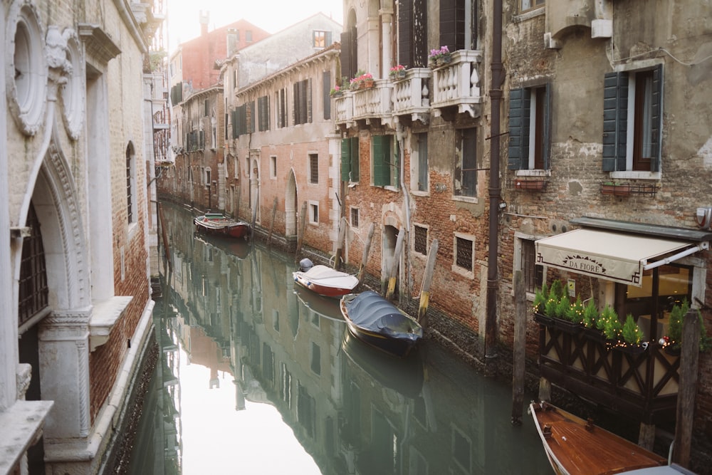 boat on river between buildings during daytime