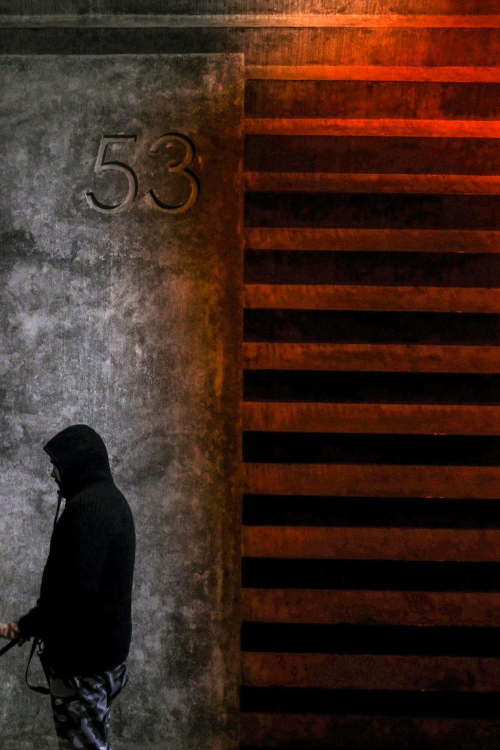 man in black suit jacket and black pants standing on brown wooden stairs