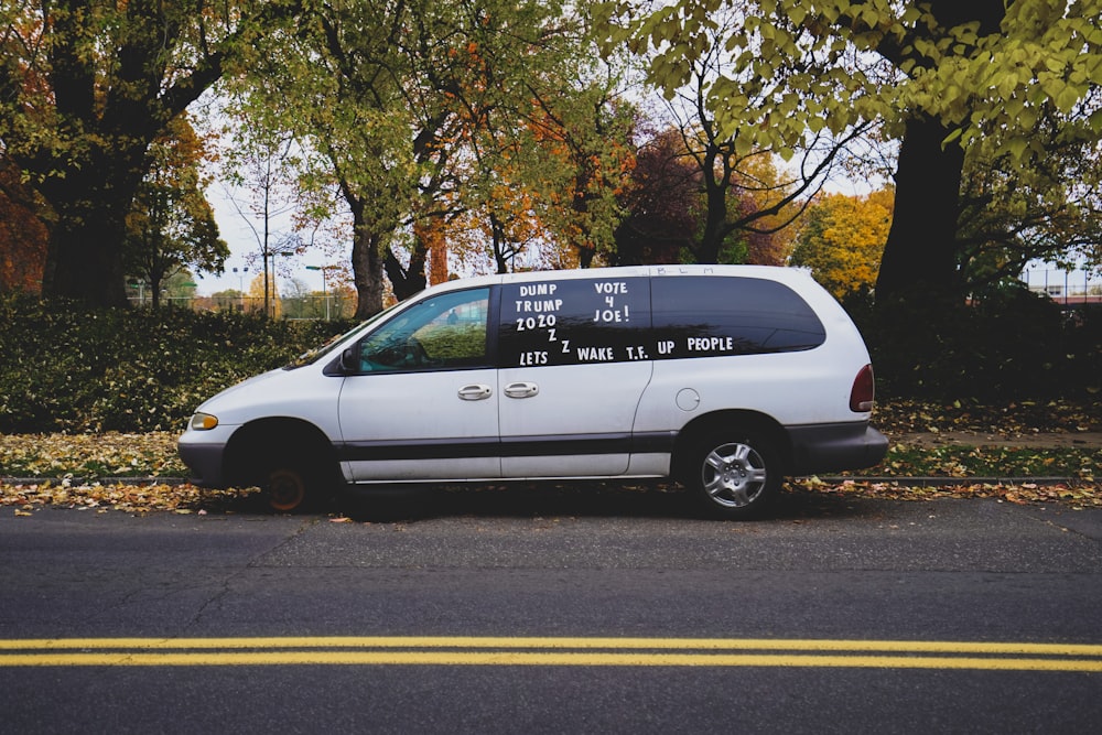 white van on road near trees during daytime