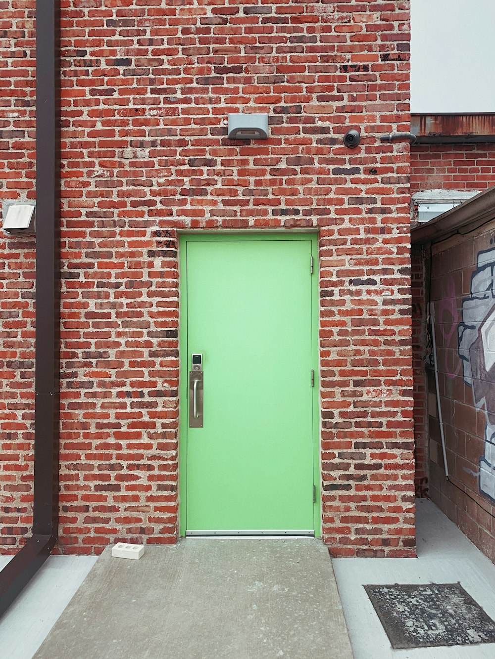 green wooden door on brown brick wall