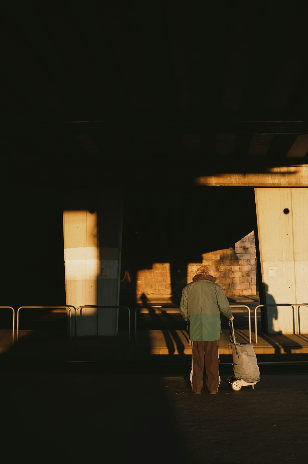 man in gray shirt and gray pants walking on sidewalk during daytime