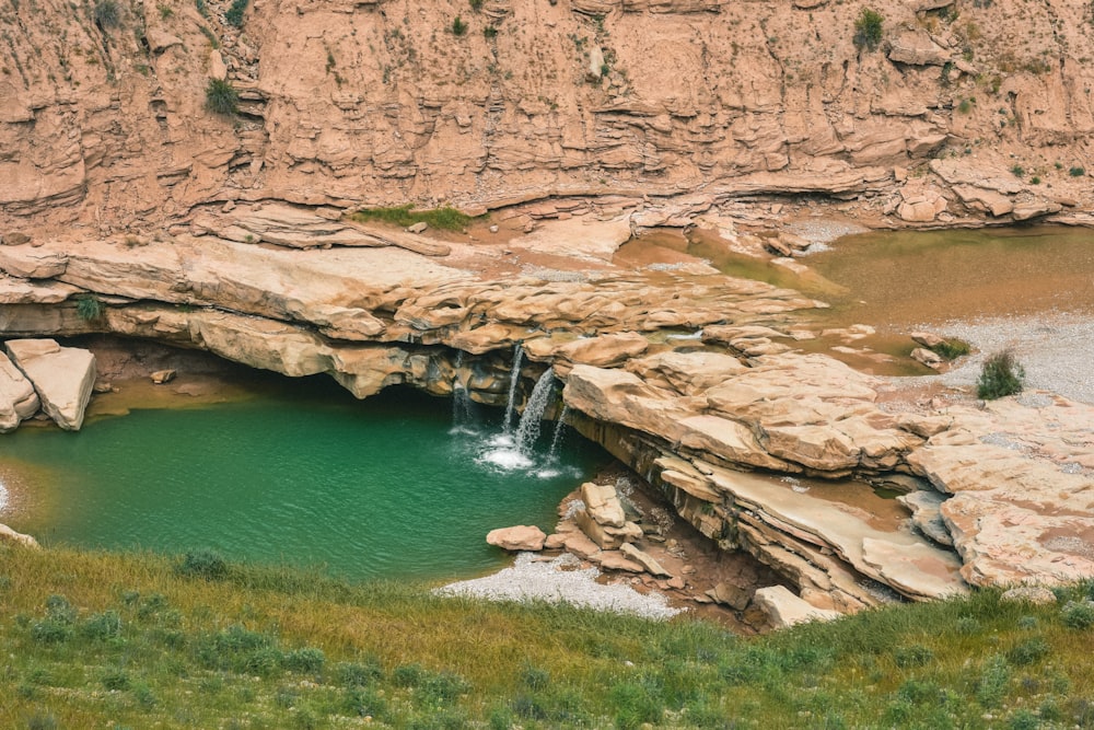 brown rocky mountain beside river during daytime