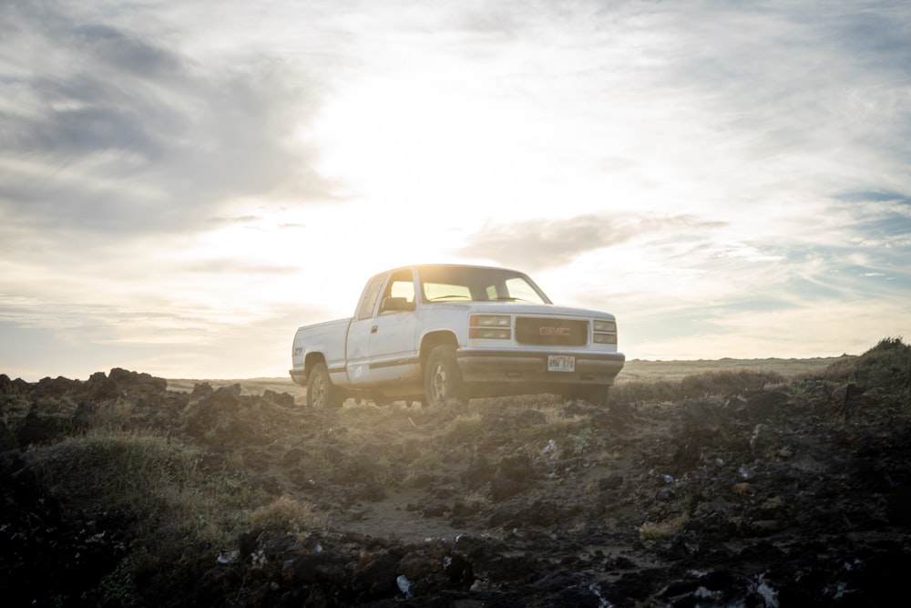 white chevrolet single cab pickup truck on brown field under white clouds during daytime