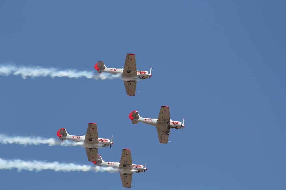 a group of airplanes flying through a blue sky