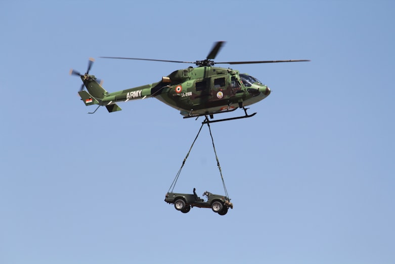 green and black helicopter flying in the sky