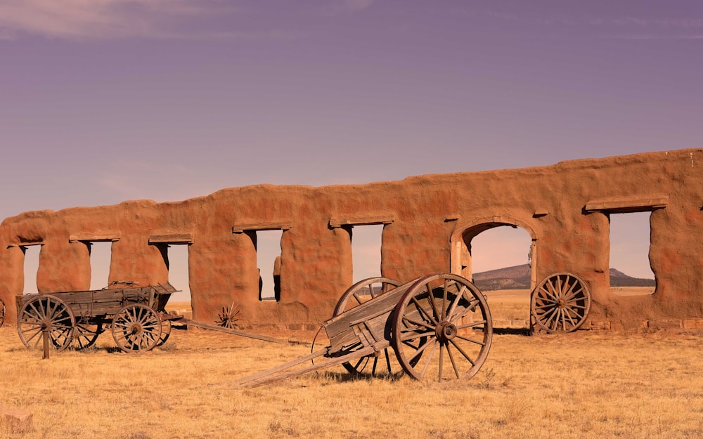 brown wooden carriage on brown sand during daytime