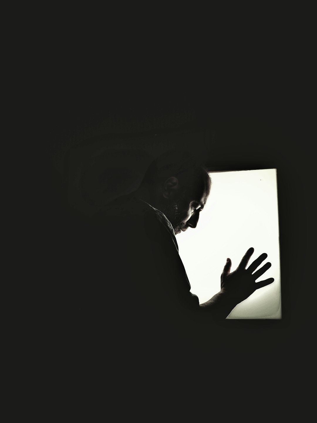 silhouette of man in front of mirror