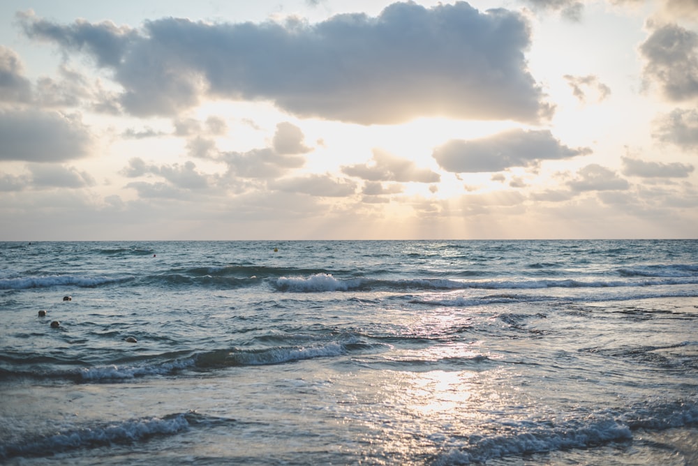 ocean waves under cloudy sky during daytime