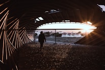 man in black jacket standing on brown sand during daytime