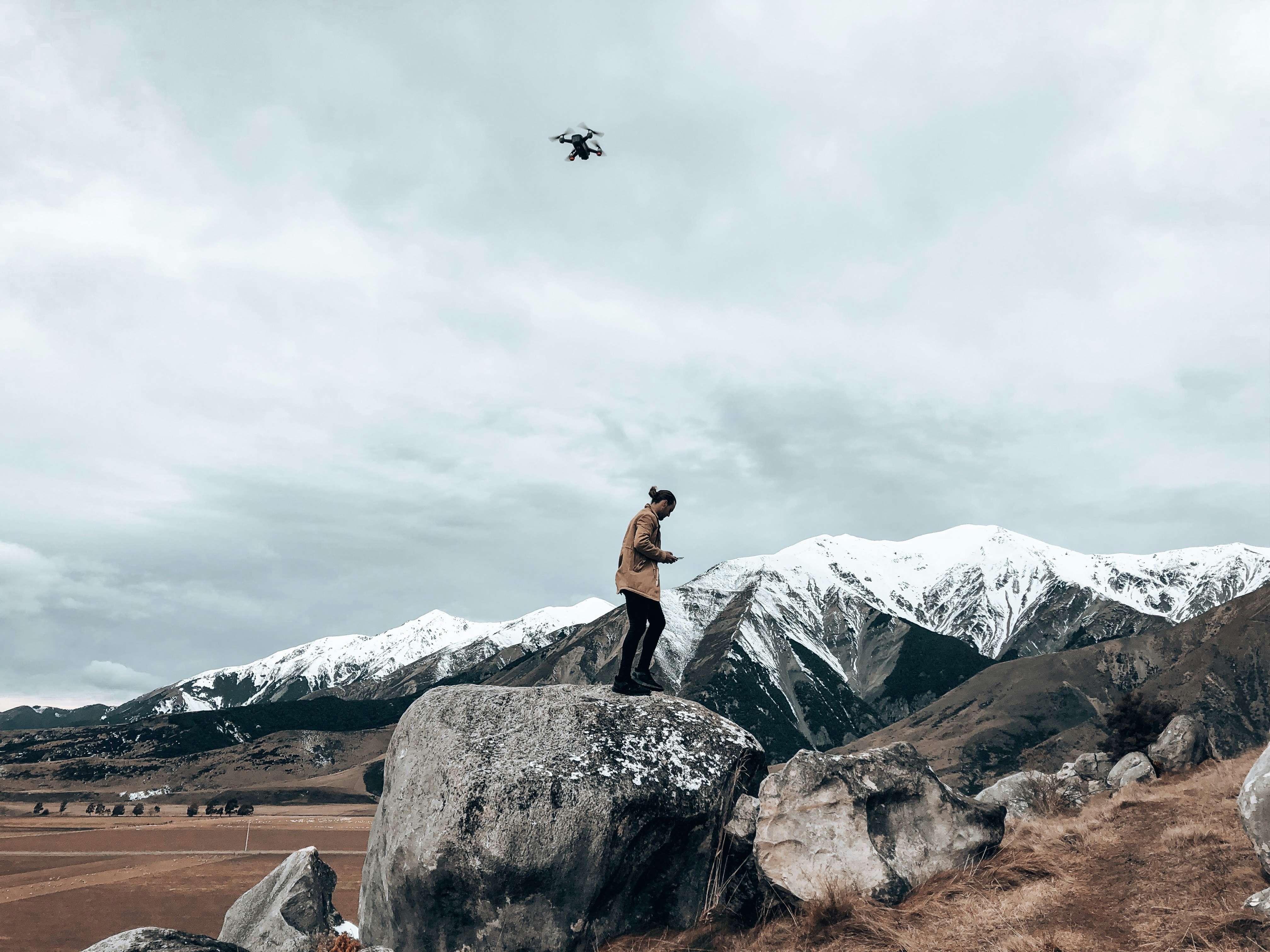 man in black tank top standing on rock formation during daytime