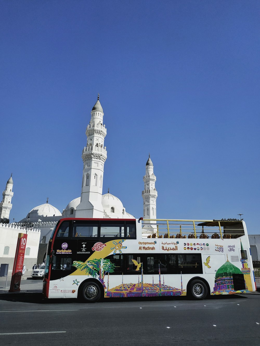 red and white bus on road near white concrete building during daytime