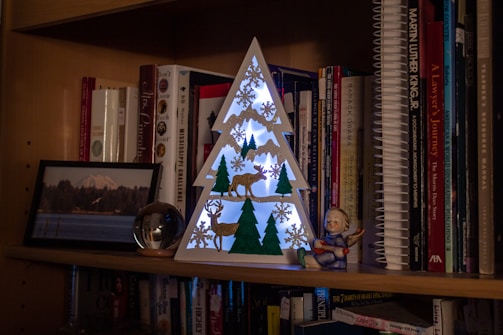 An elegant shelf displaying Christian books and decorative accents.