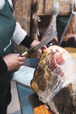 person slicing meat on table