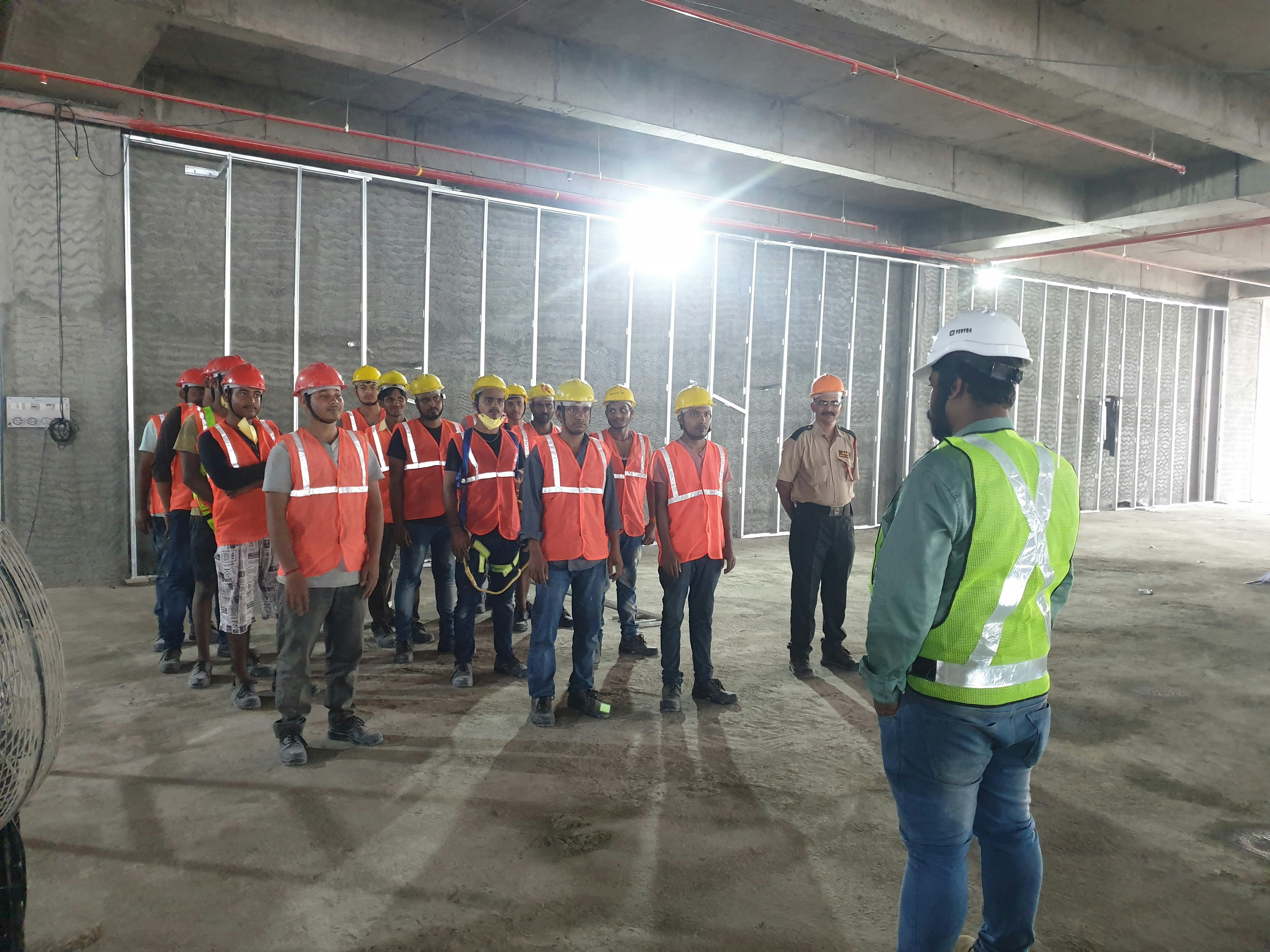 Construction workers at a job site in safety gear, team briefing outdoors