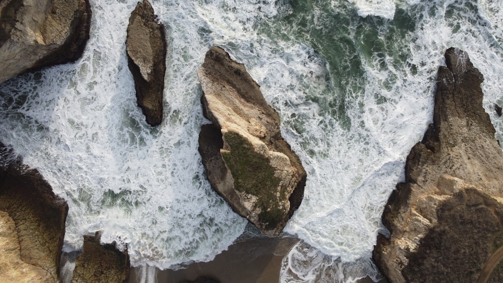 brown rock formation on body of water during daytime