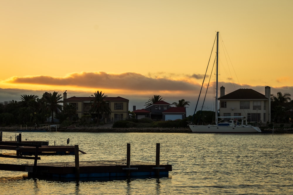 white and blue boat on dock during sunset