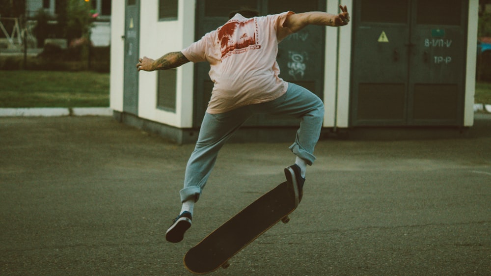 man in white t-shirt and white pants playing skateboard