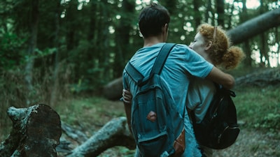 A couple hiking through a lush green forest trail.