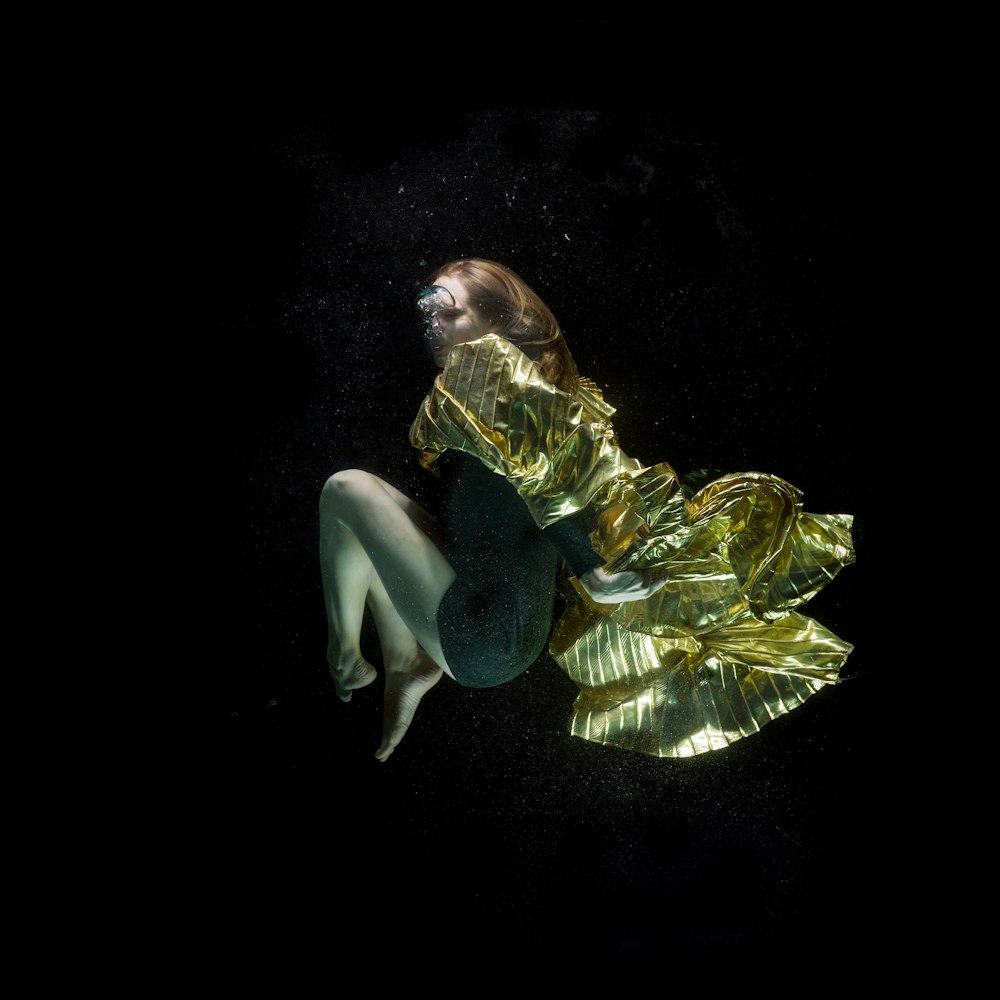 woman in green dress lying on black surface