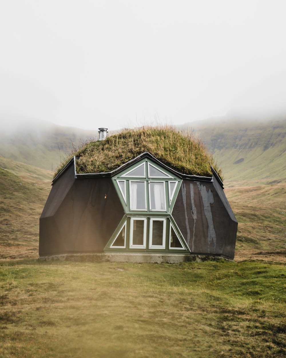 緑の芝生の上の灰色の木造家屋