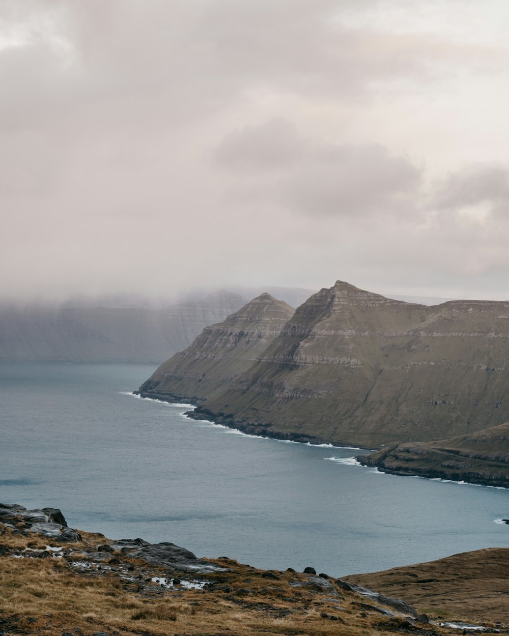 brown mountain beside body of water