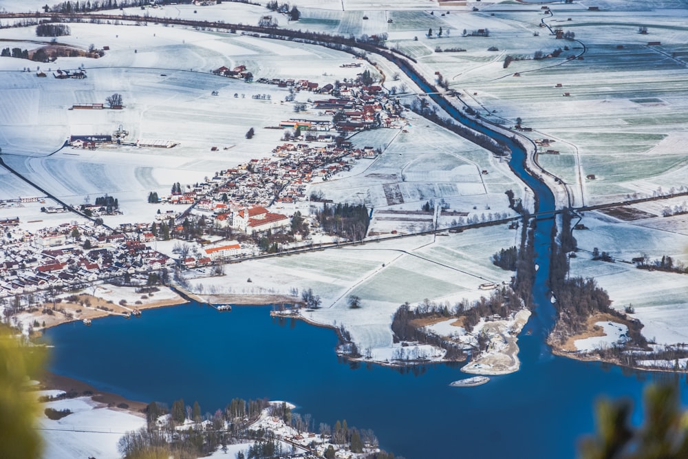 vista aérea de edifícios da cidade e árvores cobertas de neve durante o dia