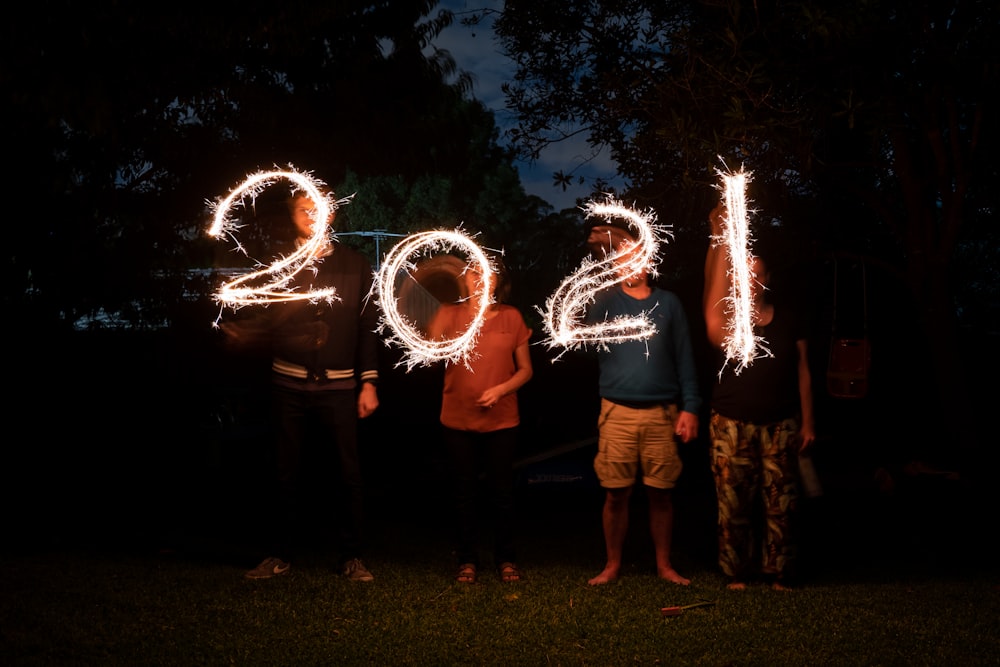 a group of people standing next to each other holding sparklers