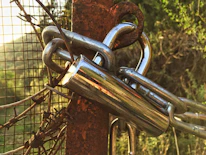 A wide shot of a custom chain link gate securing a rural property.