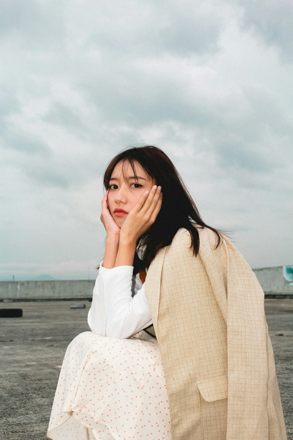 woman in white long sleeve shirt sitting on white textile