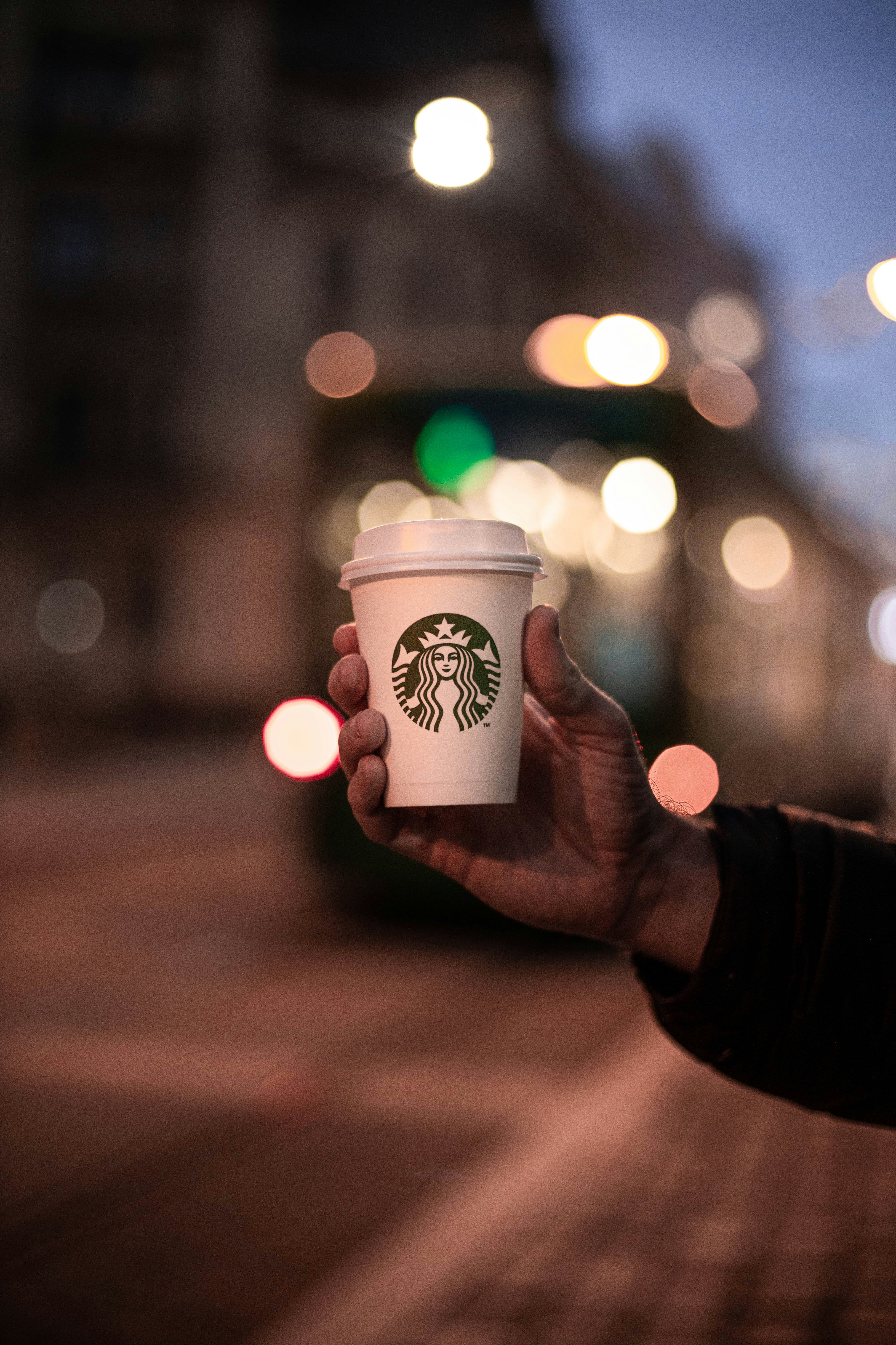 person holding white and green starbucks cup