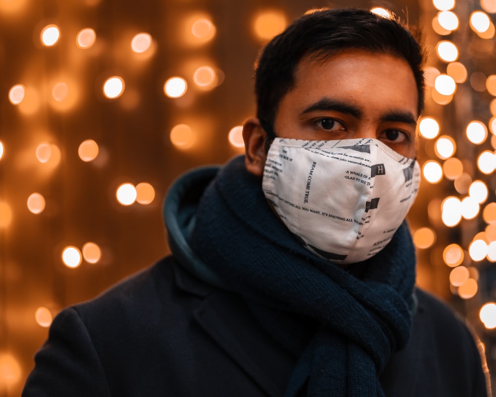 man in black hoodie wearing white face mask