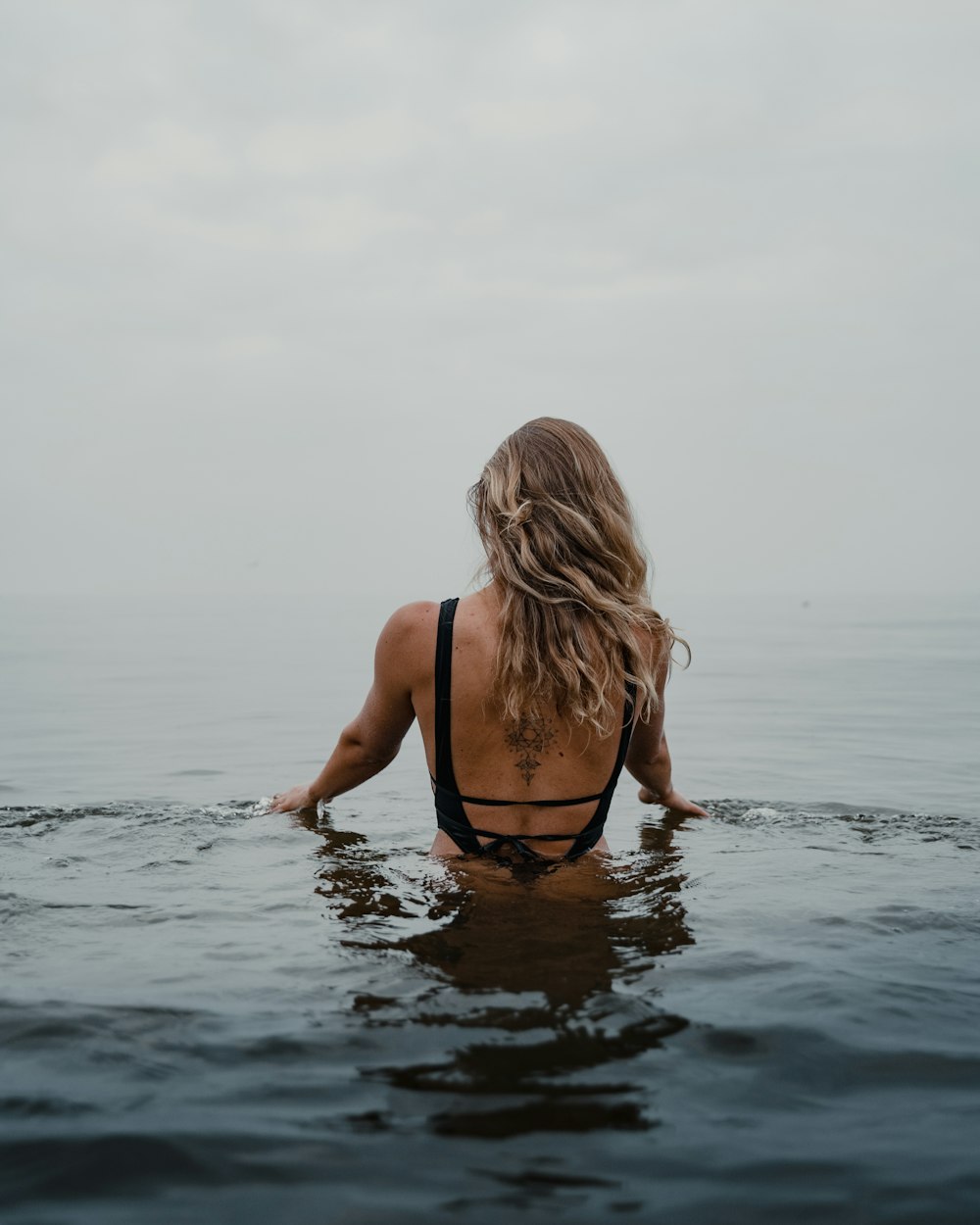 woman in black bikini on water during daytime