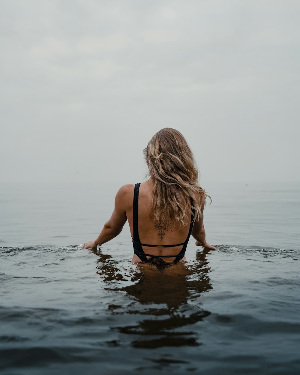 femme en bikini noir sur l’eau pendant la journée