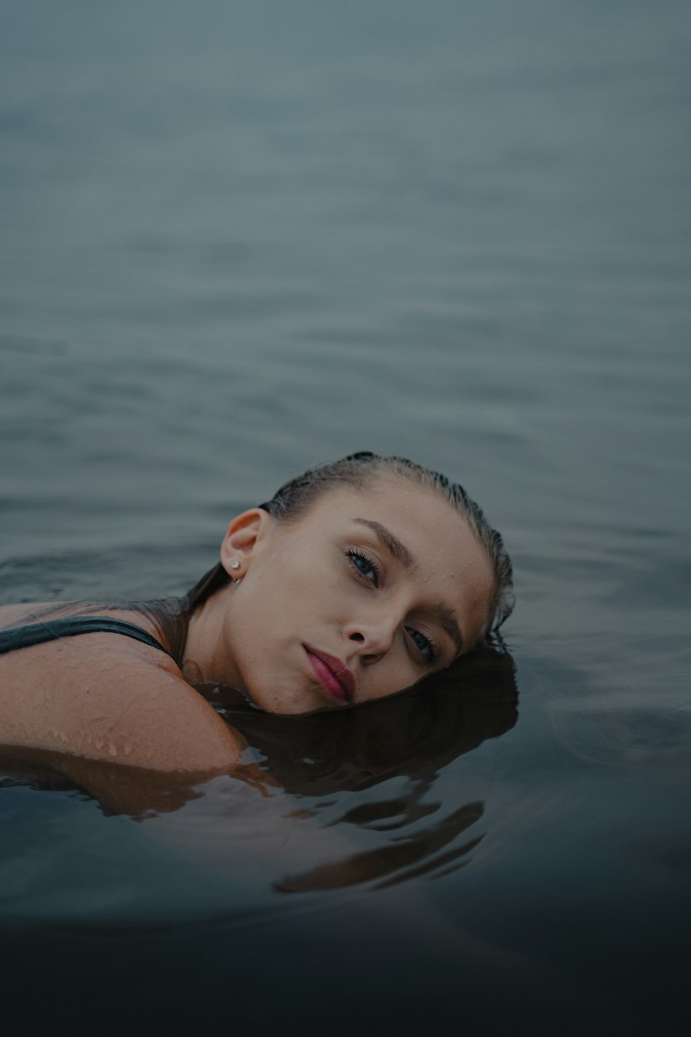 Mujer con camiseta sin mangas a rayas azules y blancas en el agua