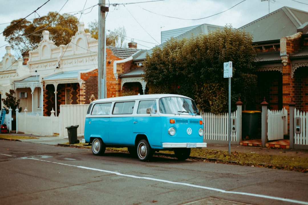 blue and white volkswagen t-2 parked on sidewalk during daytime