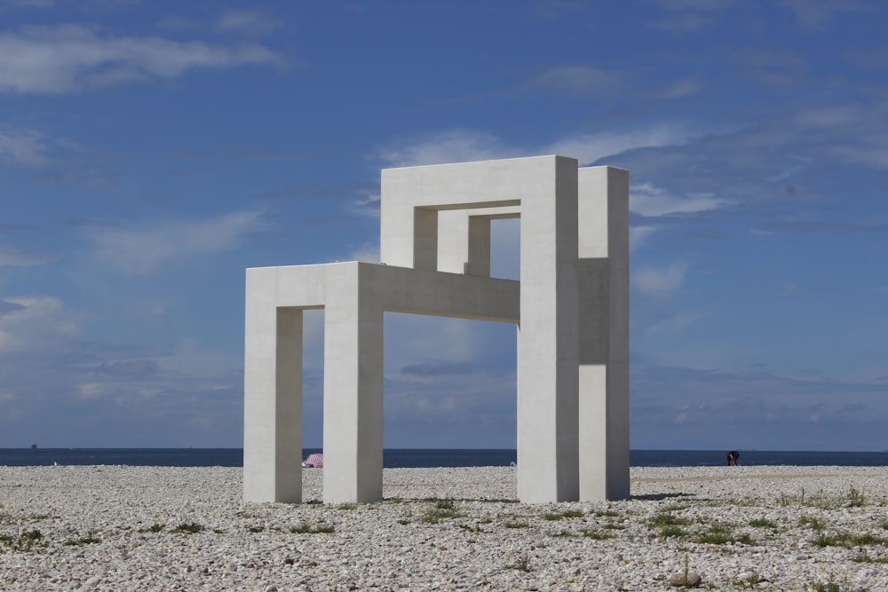 낮 동안 회색 모래 위에 흰색 콘크리트 기둥