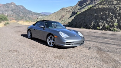A sleek car parked on a scenic road ready for a road trip.