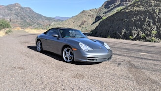A sleek rental car parked beside a mountain road, ready for adventure.