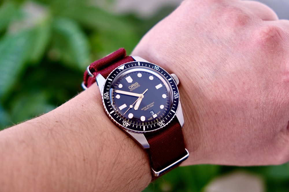 person wearing black and silver analog watch