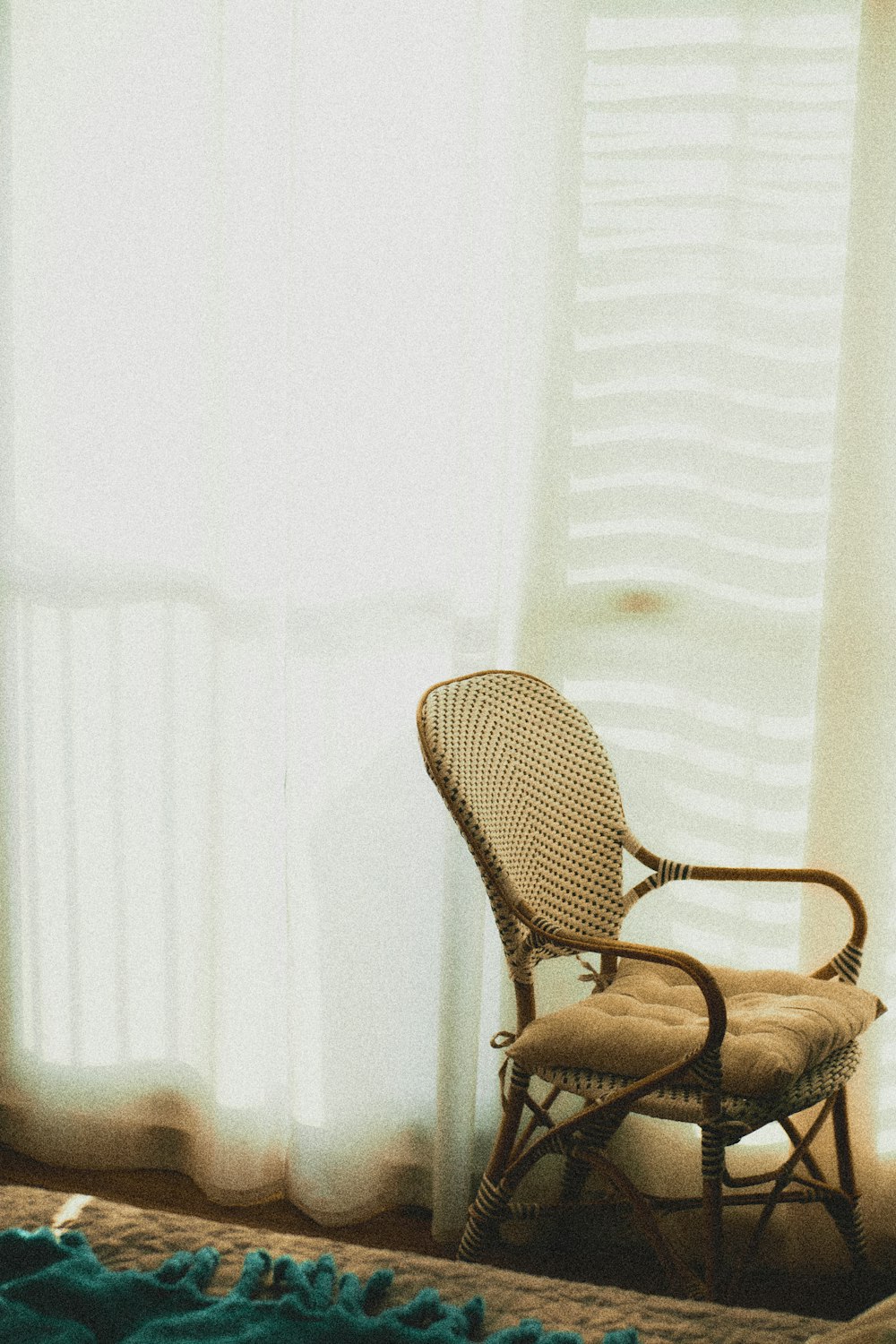 fauteuil en bois marron à côté d’un mur blanc